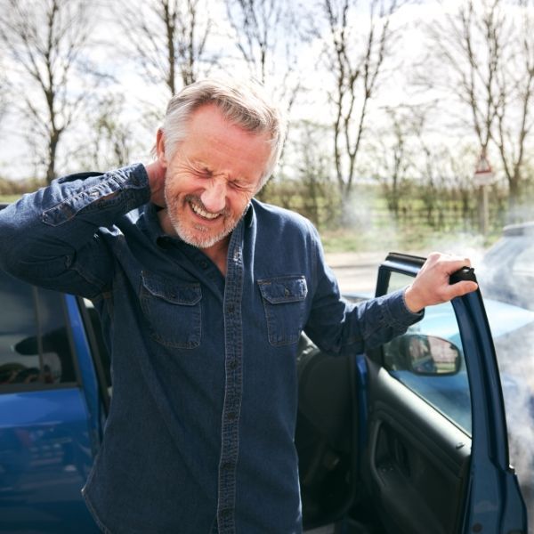 a man in a blue jacket after a Auto Injury in pain