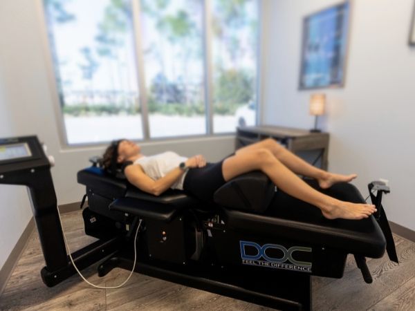 A woman is laying on a spinal decompression table at Murdock Spine and Wellness