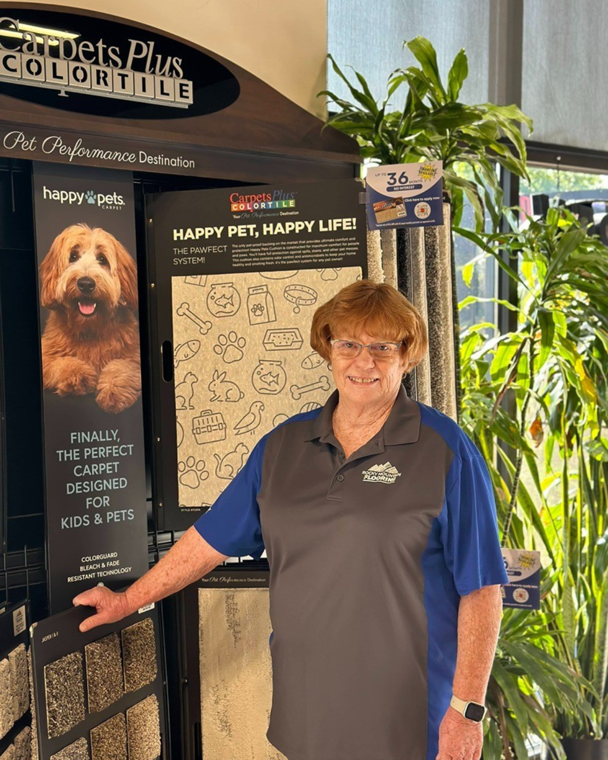 A woman is standing in front of a display of carpets.