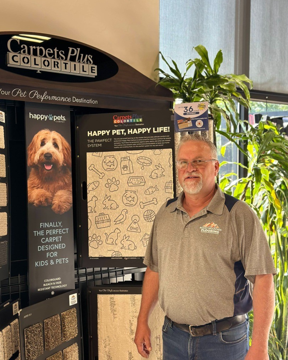 A man is standing in front of a display of carpets and tiles.