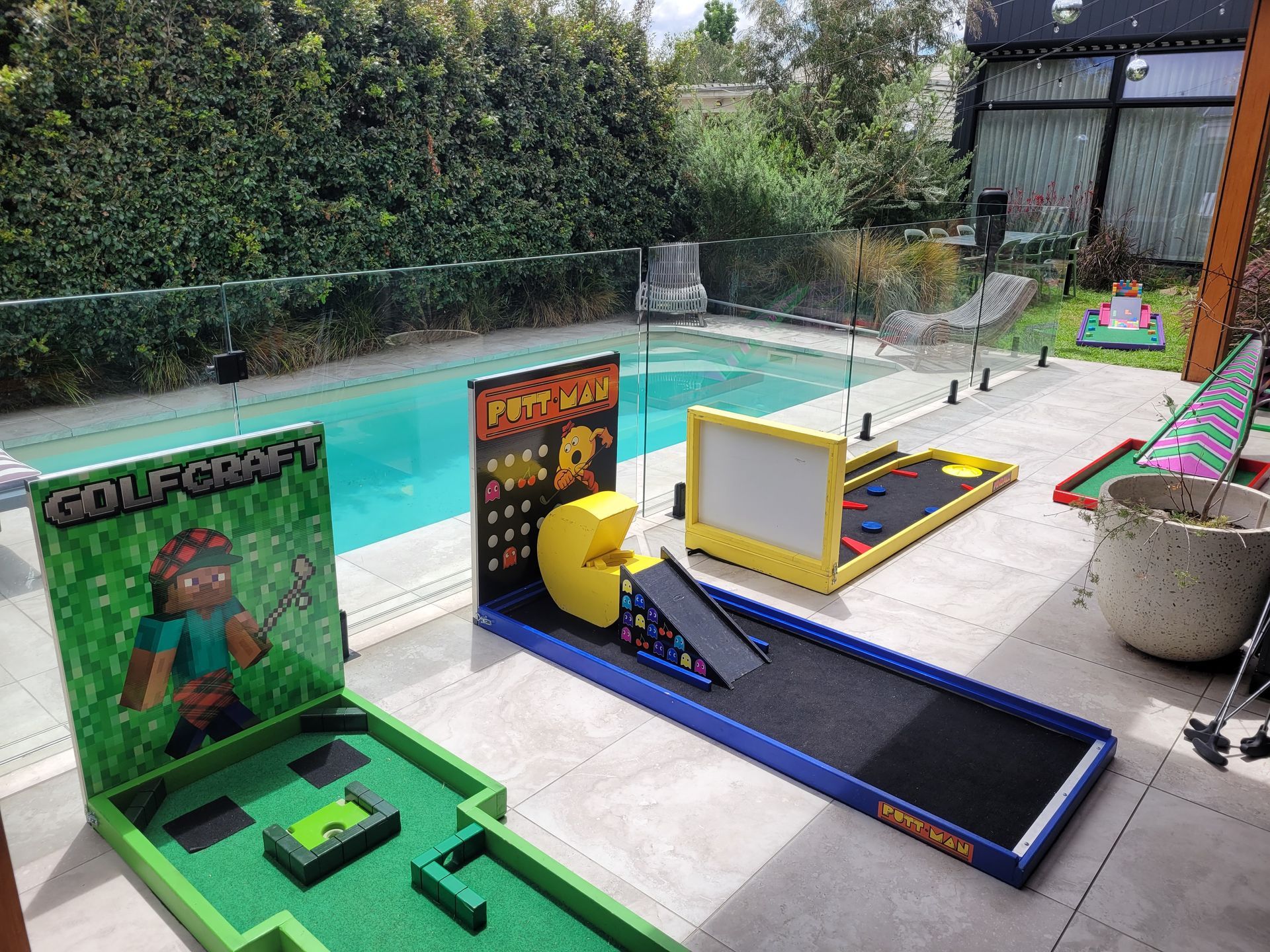 Miniature golf course featuring video game themes, near a pool.