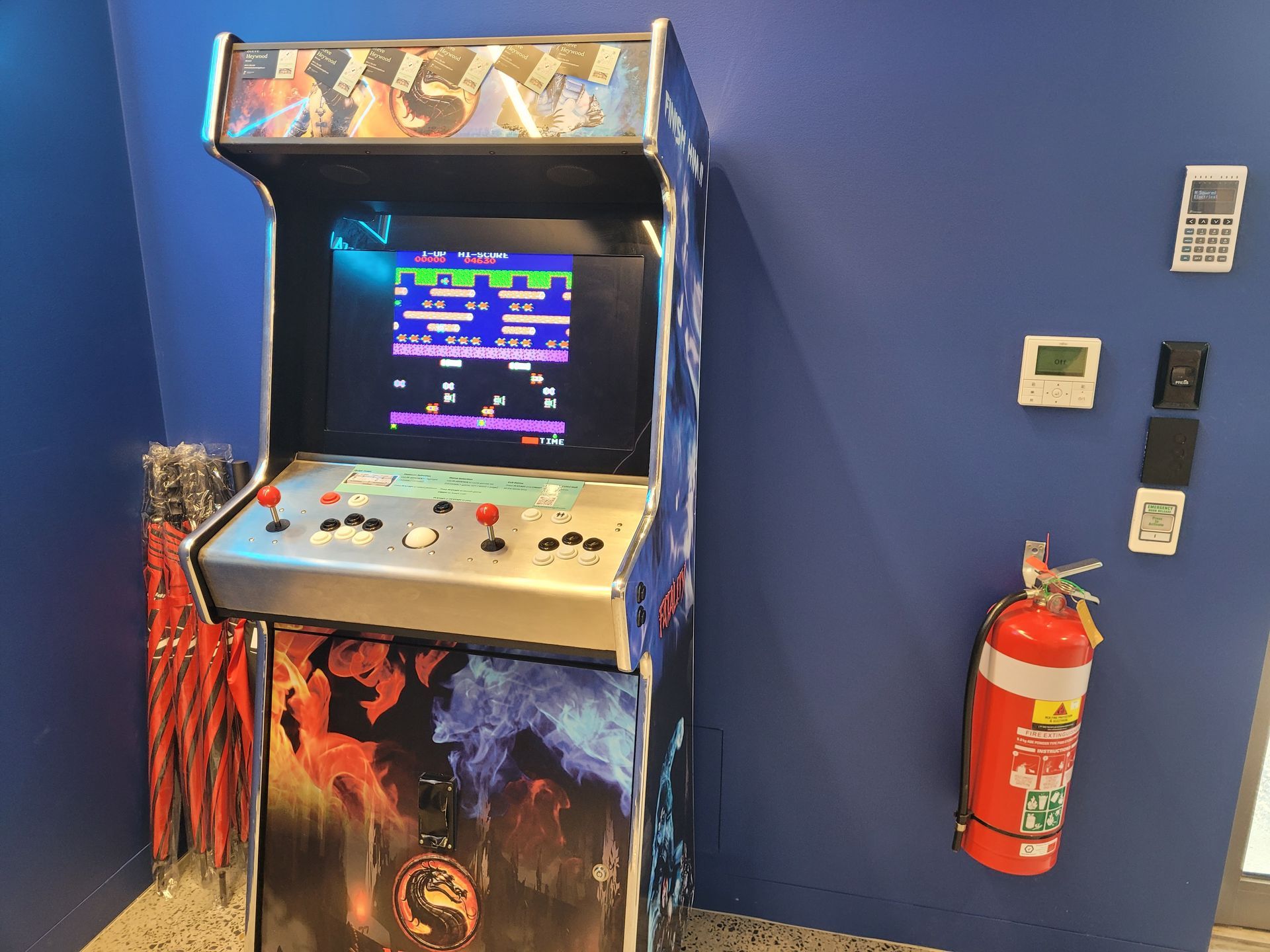 Arcade table with a screen displaying a Frogger game and buttons.