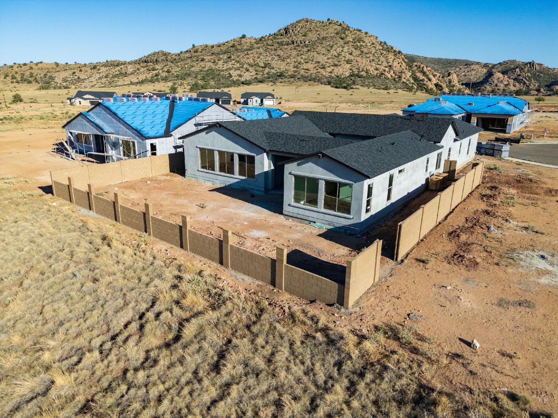 New houses under construction with a desert mountain backdrop.