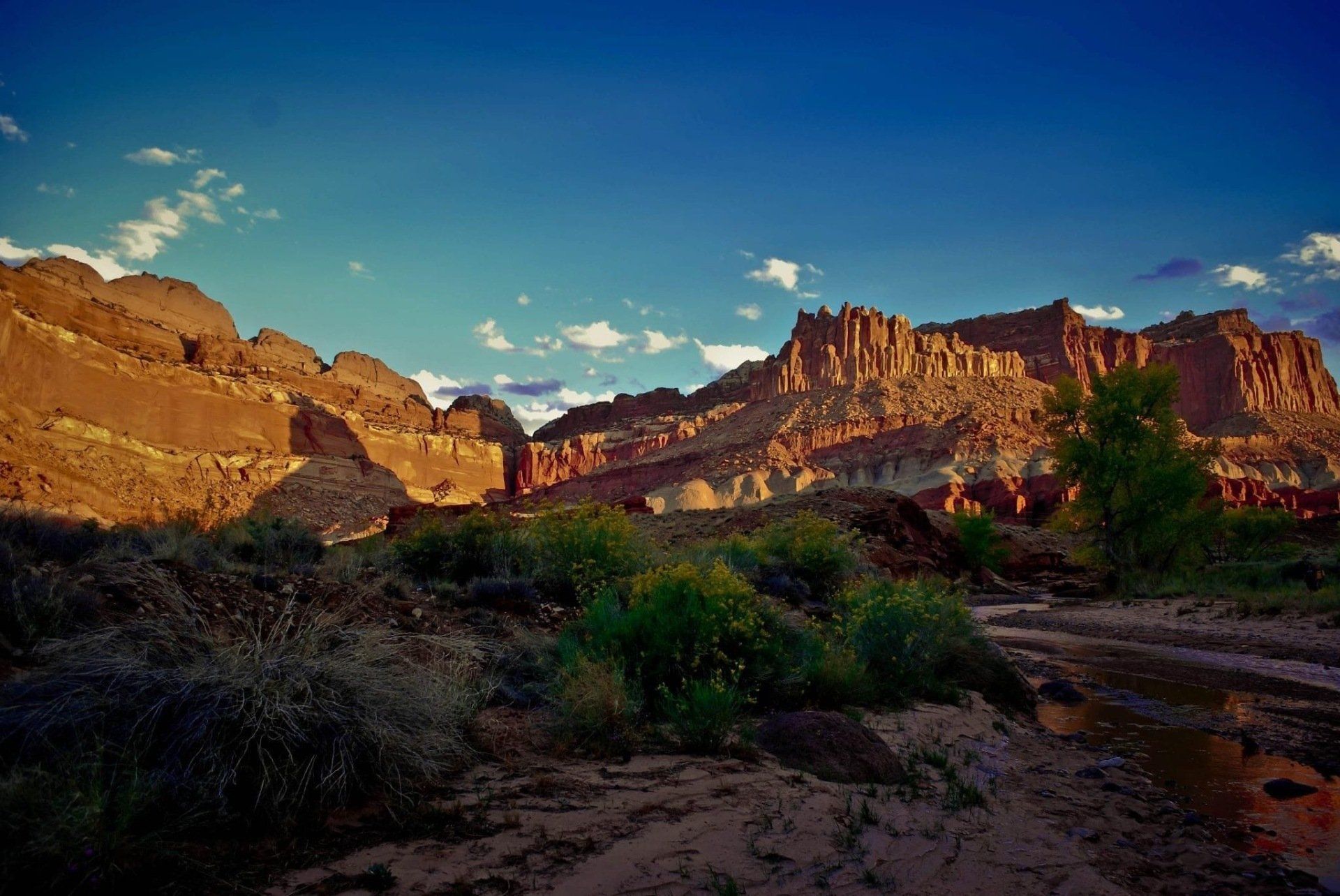 A desert landscape with mountains in the background and a river in the foreground.