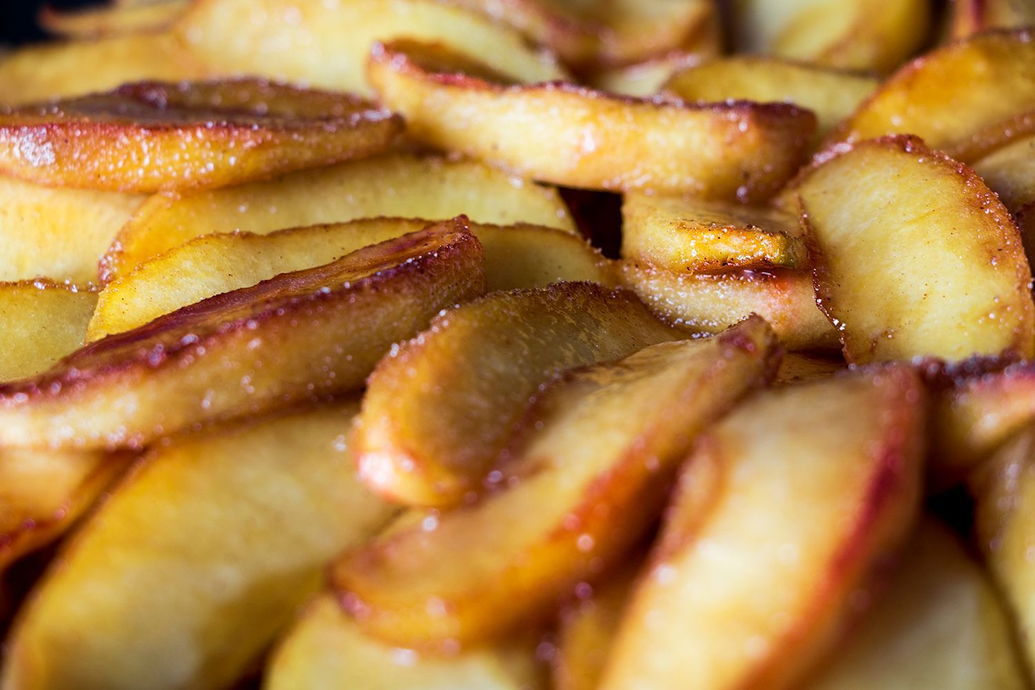 A close up of fried apple slices in a pan.