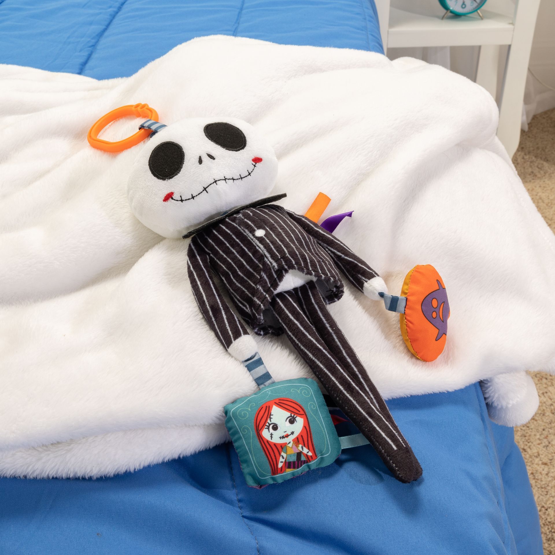 A jack skellington stuffed animal is laying on a bed