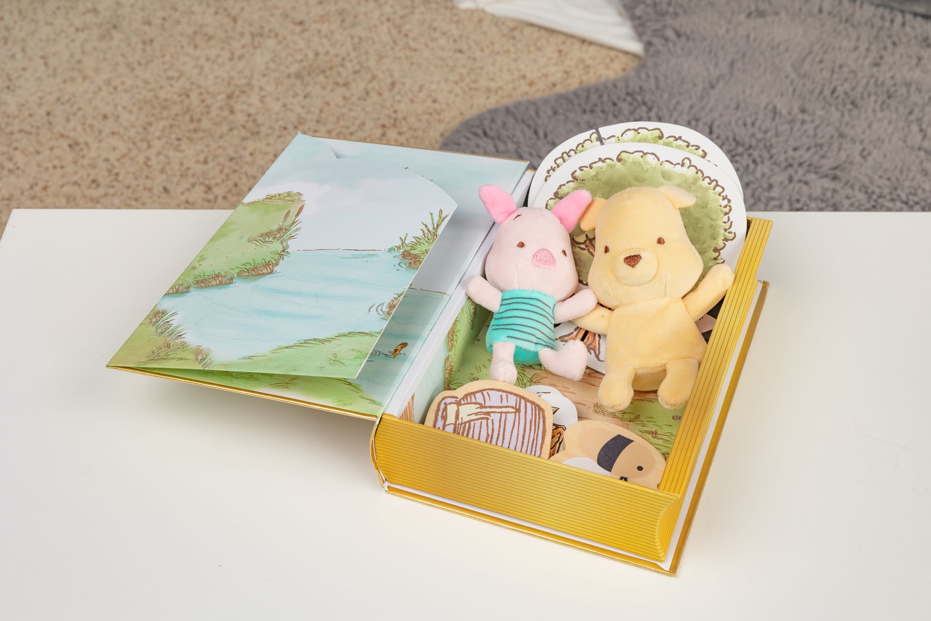 A book with two stuffed animals in it is sitting on a table.