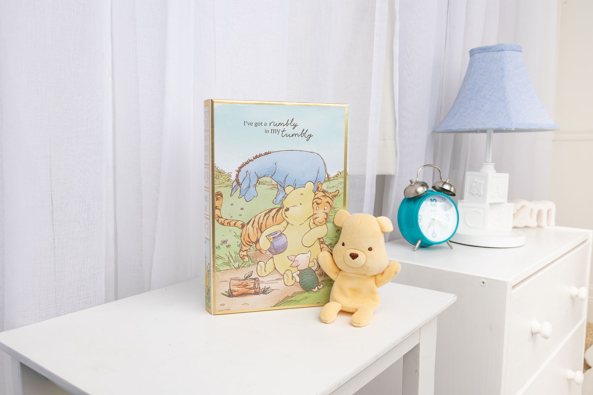 A winnie the pooh book is sitting on a table next to a stuffed animal.