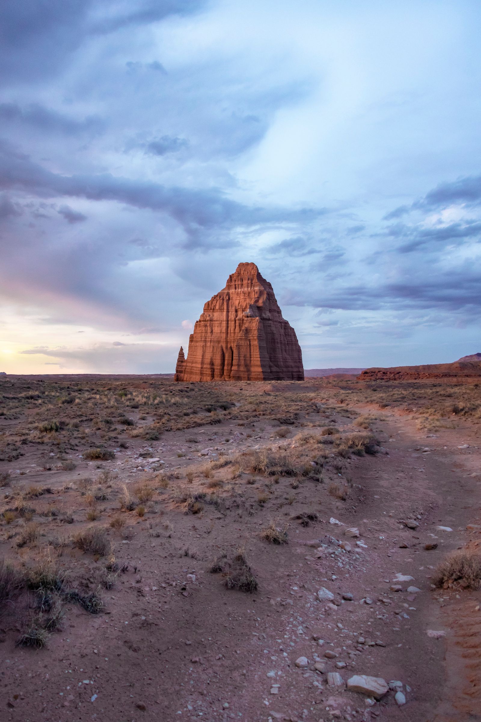 A large rock formation in the middle of a desert.
