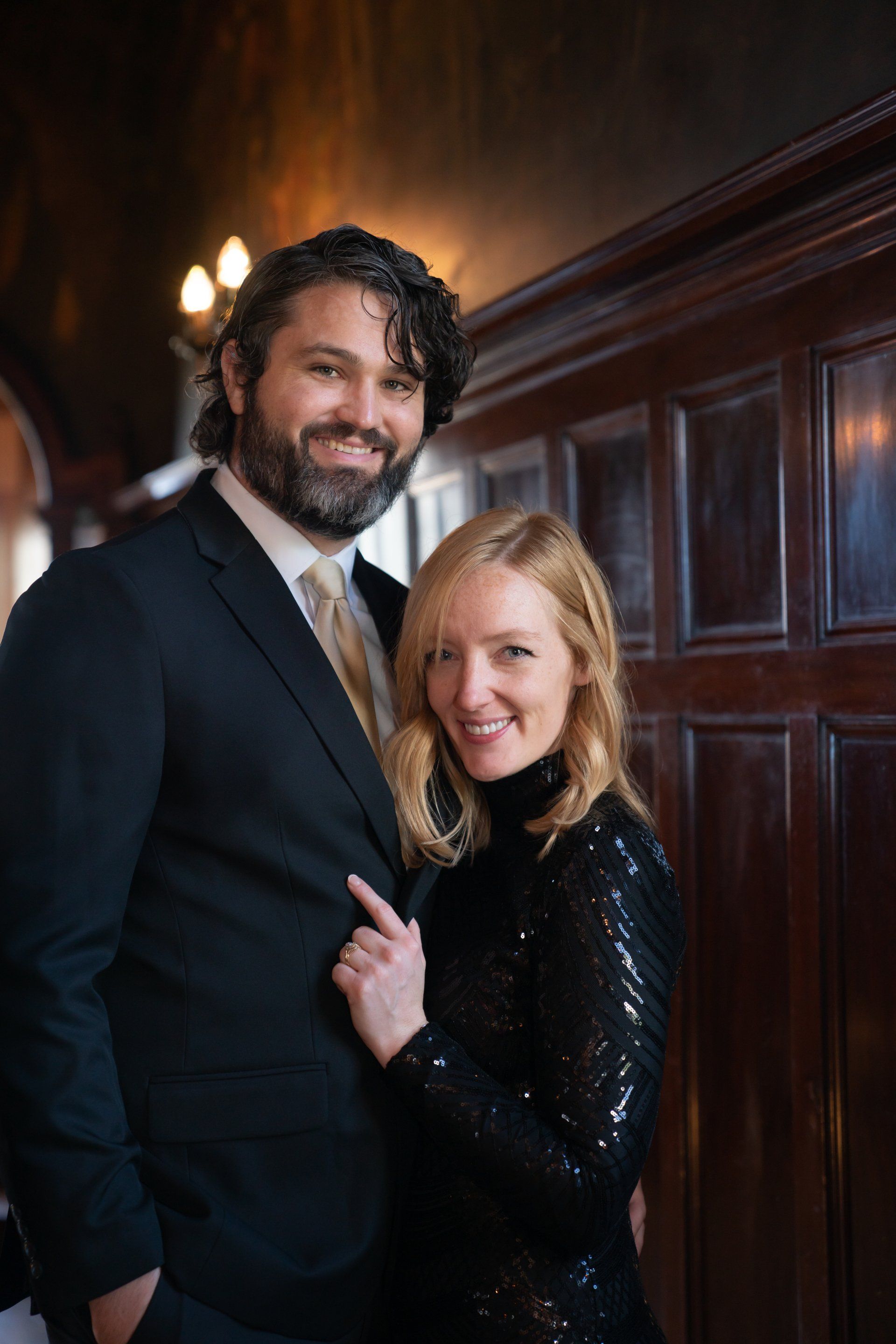 A man in a suit and tie is standing next to a woman in a black dress.