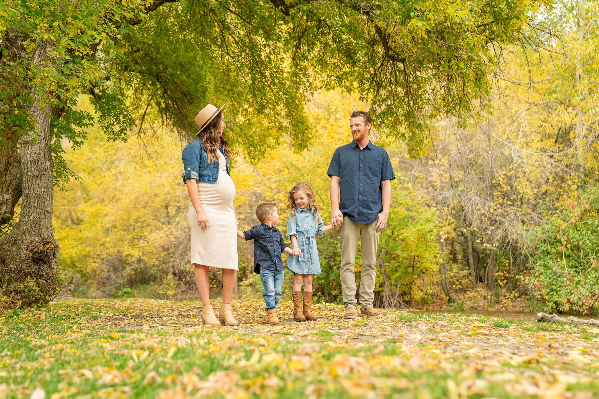 A family is standing in a park holding hands.