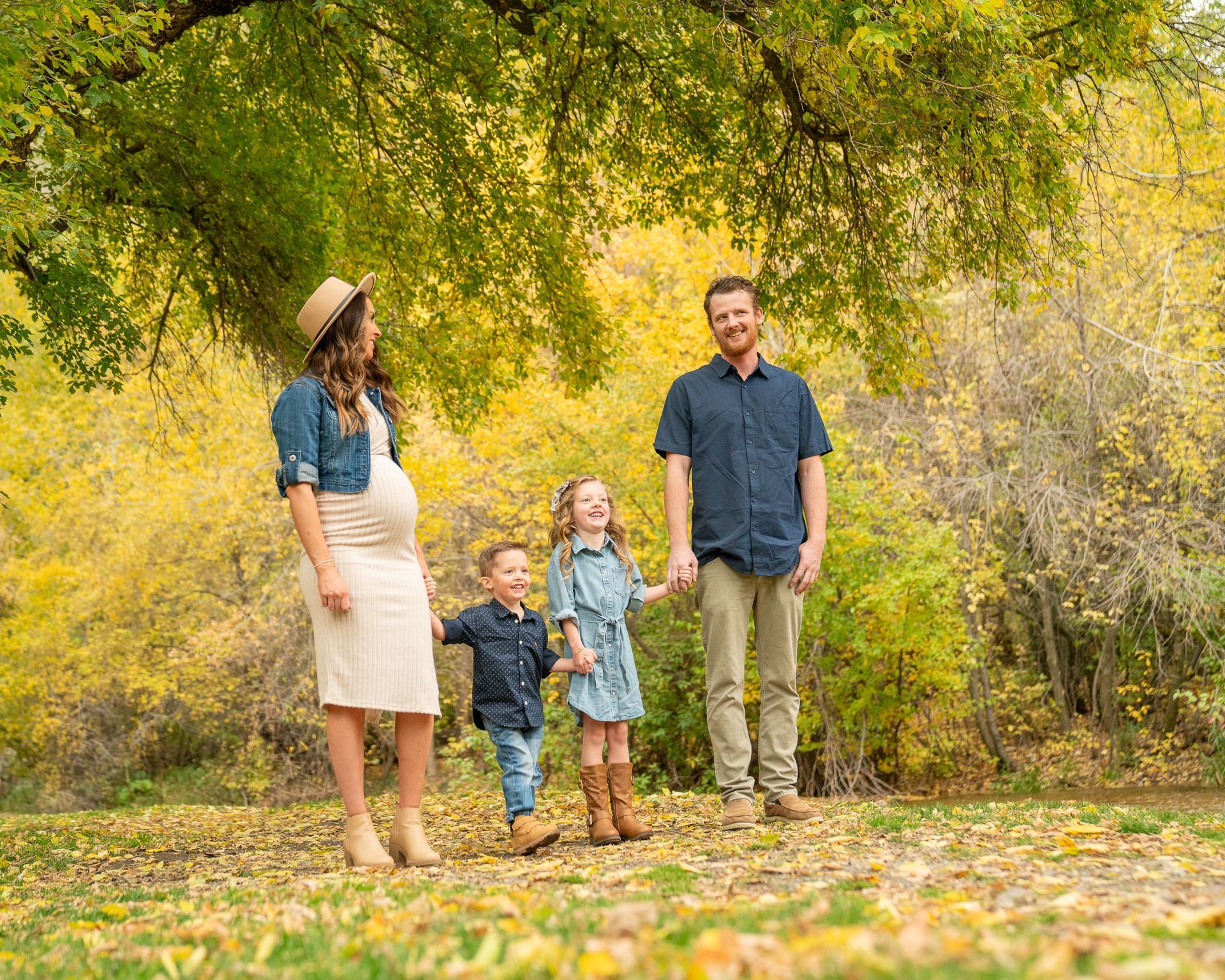 A family is standing in a park holding hands.