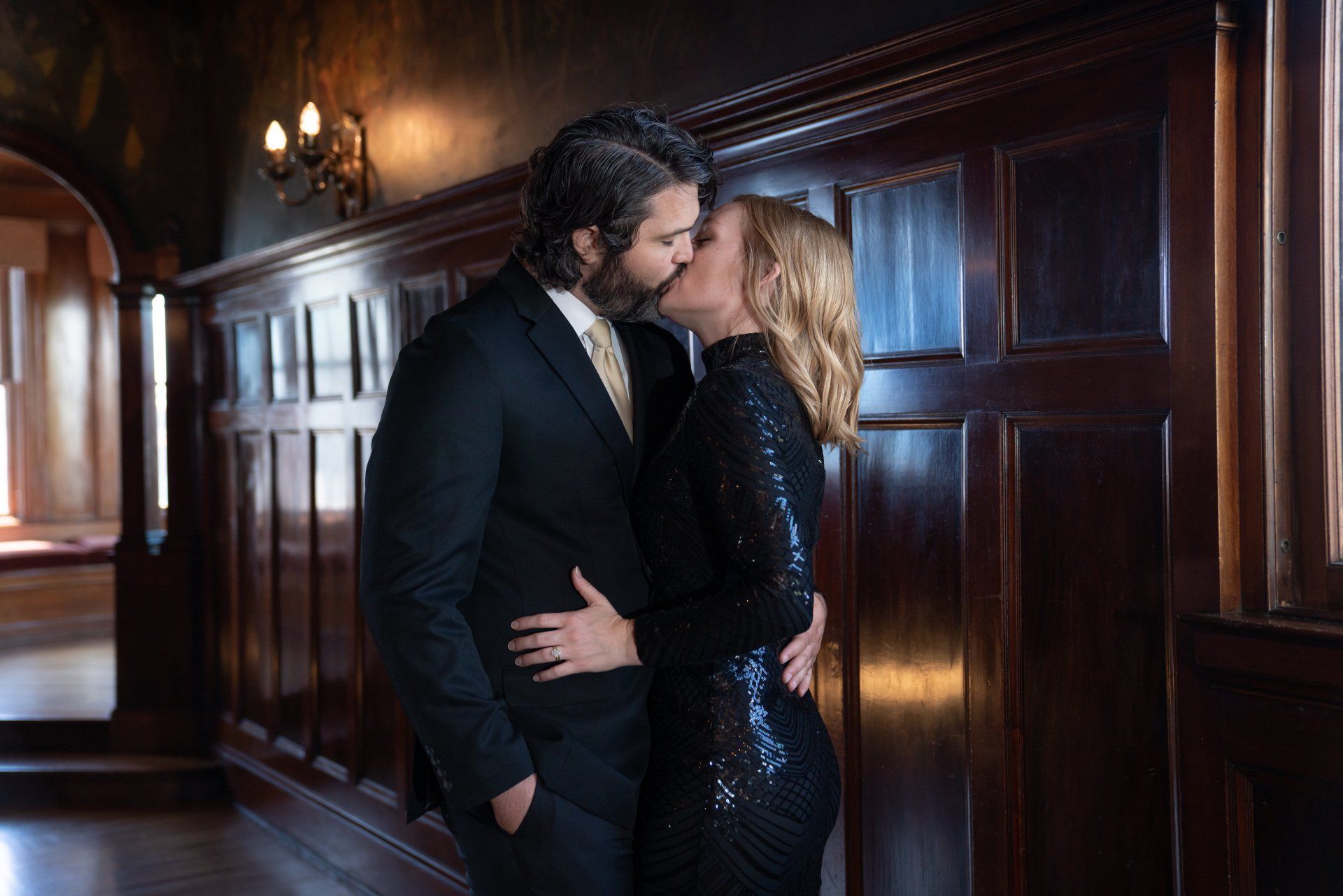 A man and a woman are kissing in a hallway.