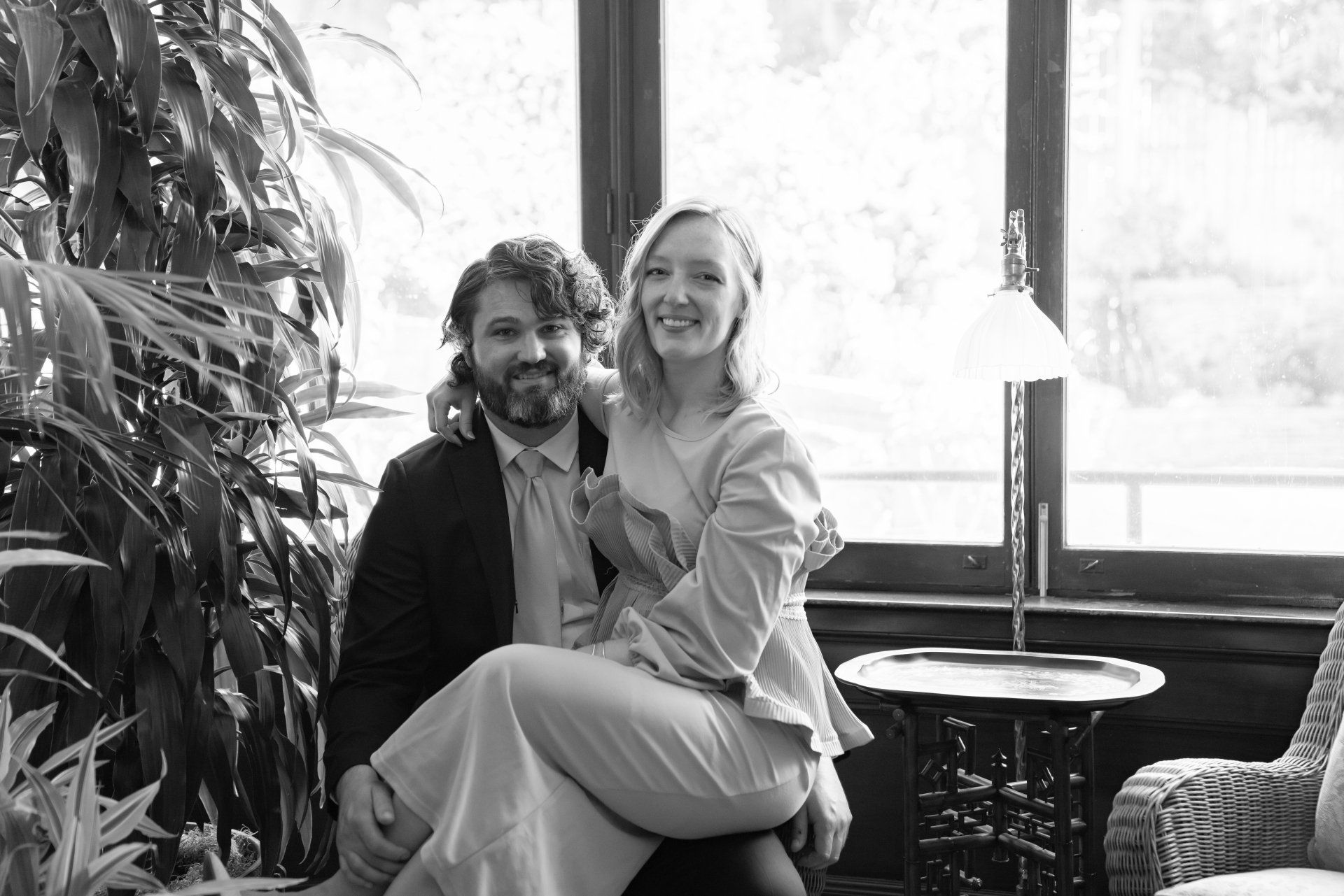 A man is sitting on a woman 's lap in a black and white photo.