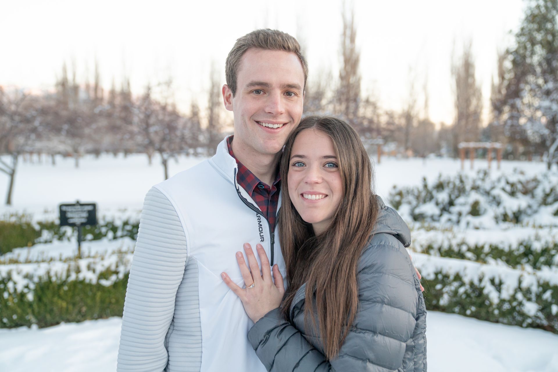 A man and a woman are posing for a picture in the snow.