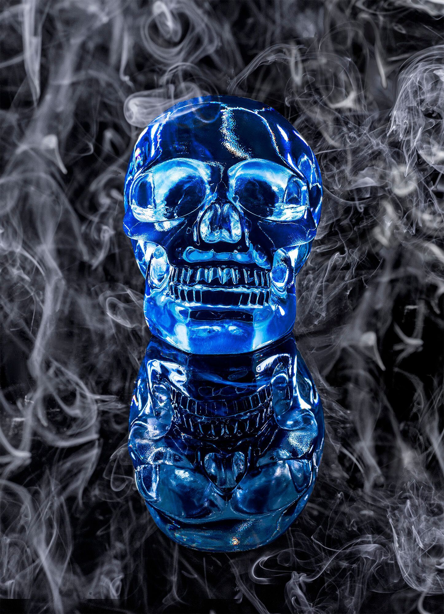 A blue skull is surrounded by smoke on a black background.