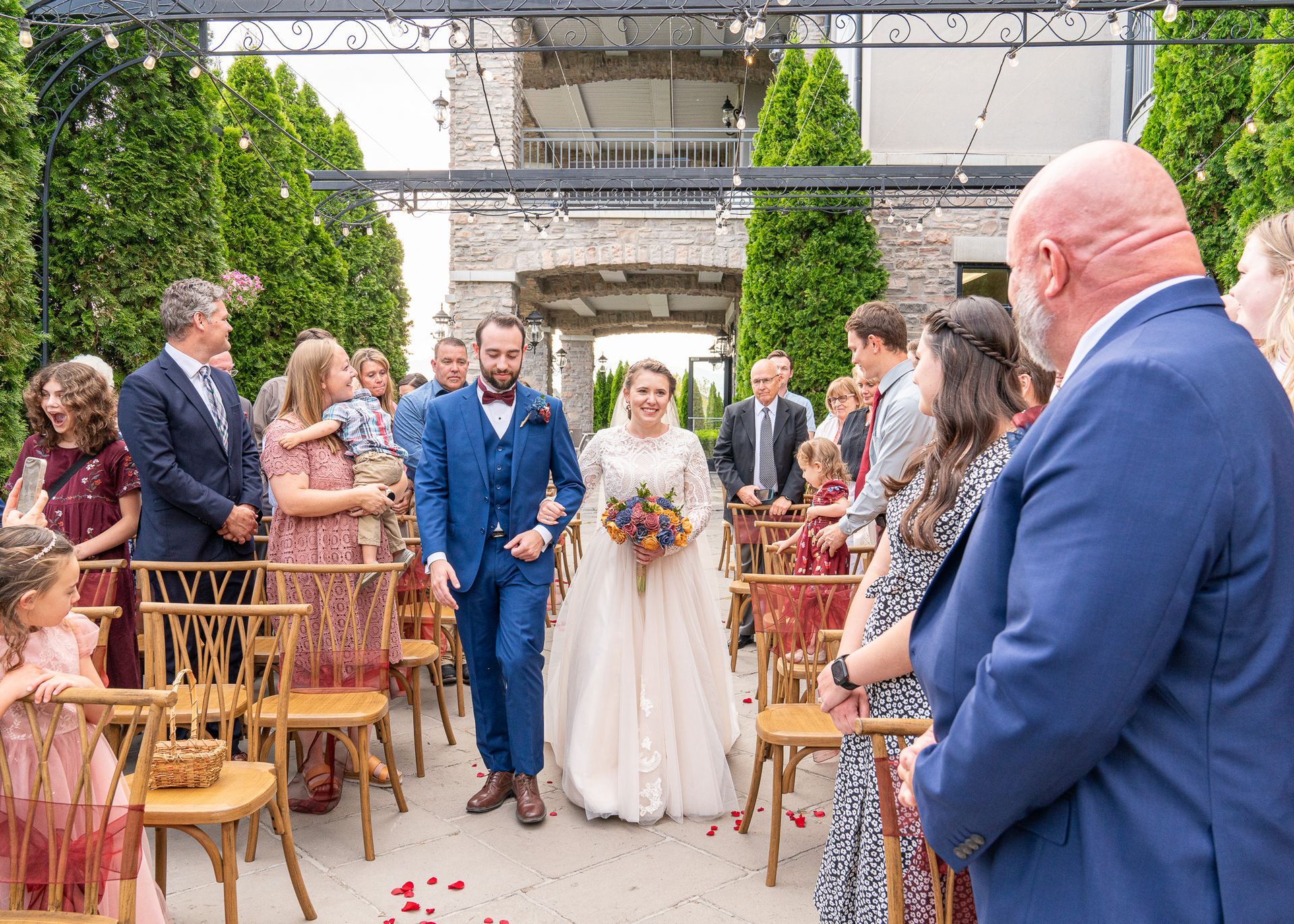 A bride and groom are walking down the aisle at their wedding.