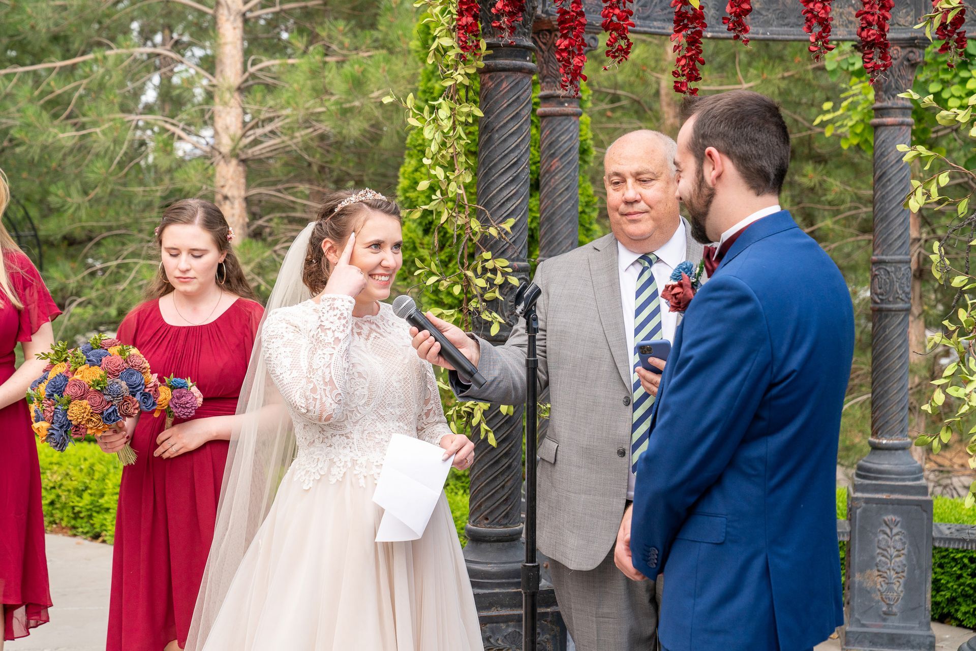 A bride and groom are standing in front of a microphone at their wedding ceremony.