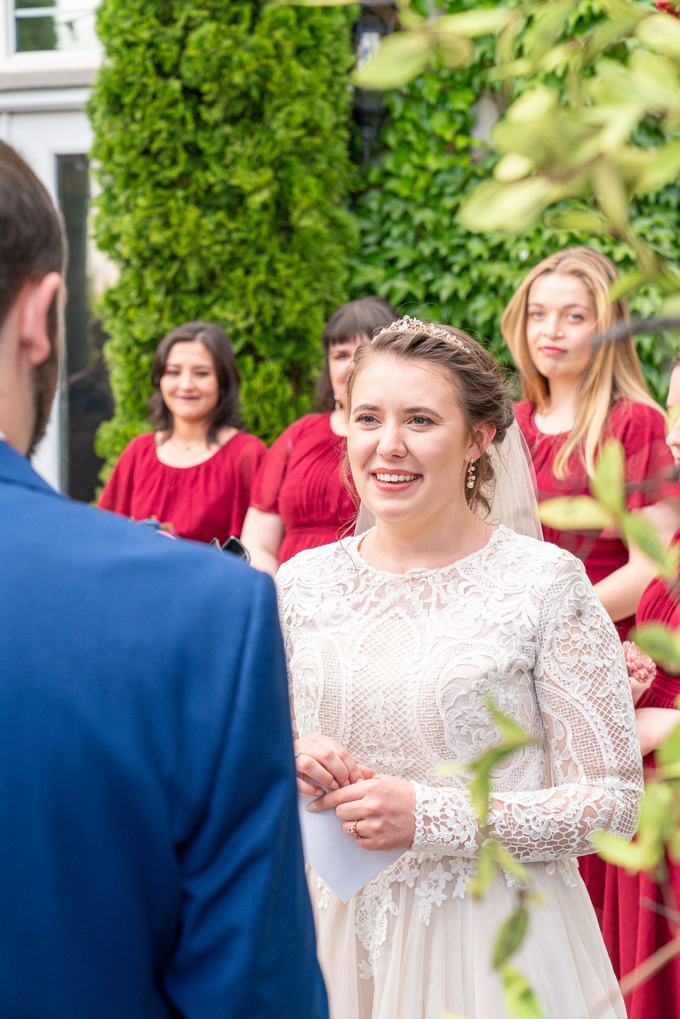 A bride and groom are getting married and the bride is smiling at the groom.