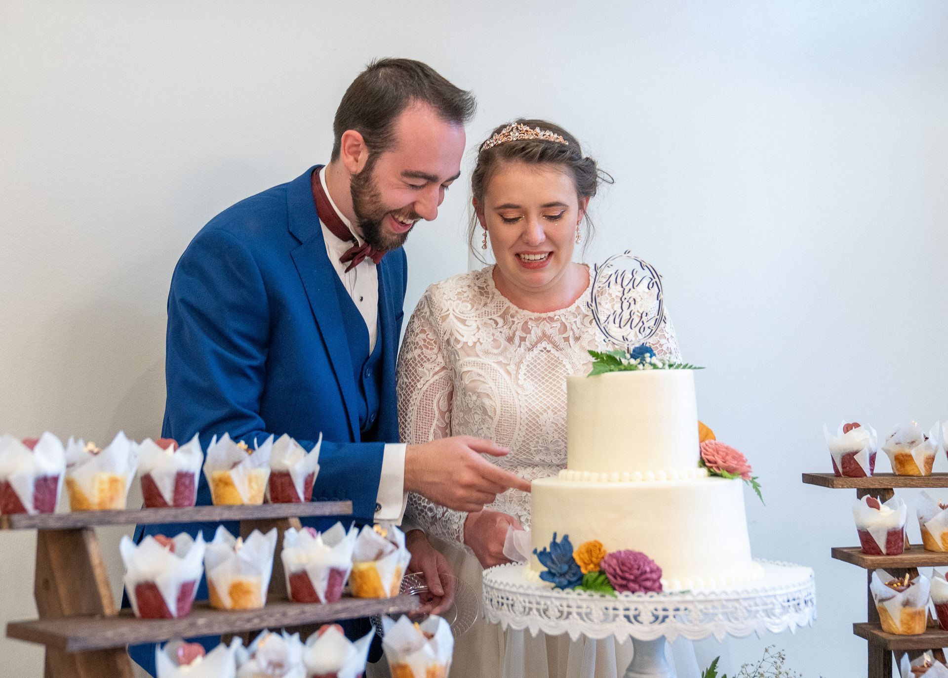 A bride and groom are cutting their wedding cake.
