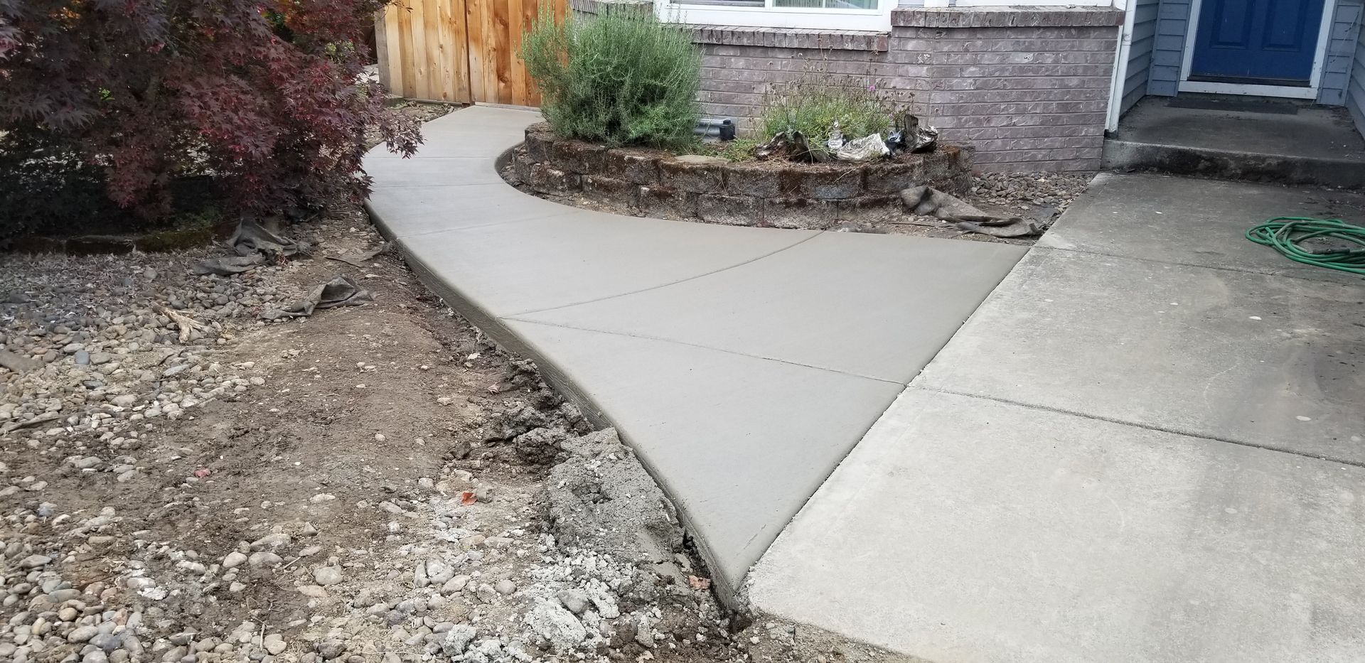 A concrete walkway is being built in front of a house.