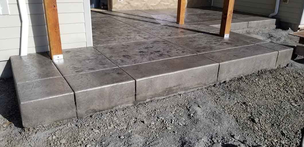 A concrete walkway is being built in front of a house.