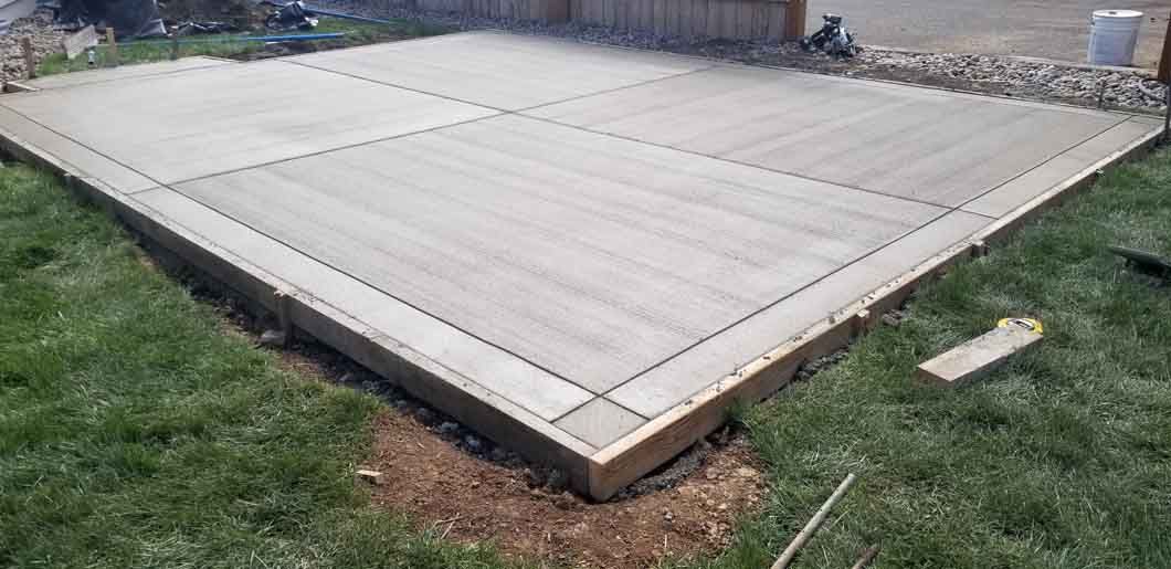 A concrete floor is sitting on top of a lush green lawn.