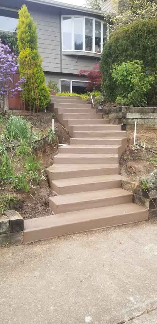 A set of concrete stairs leading up to a house.