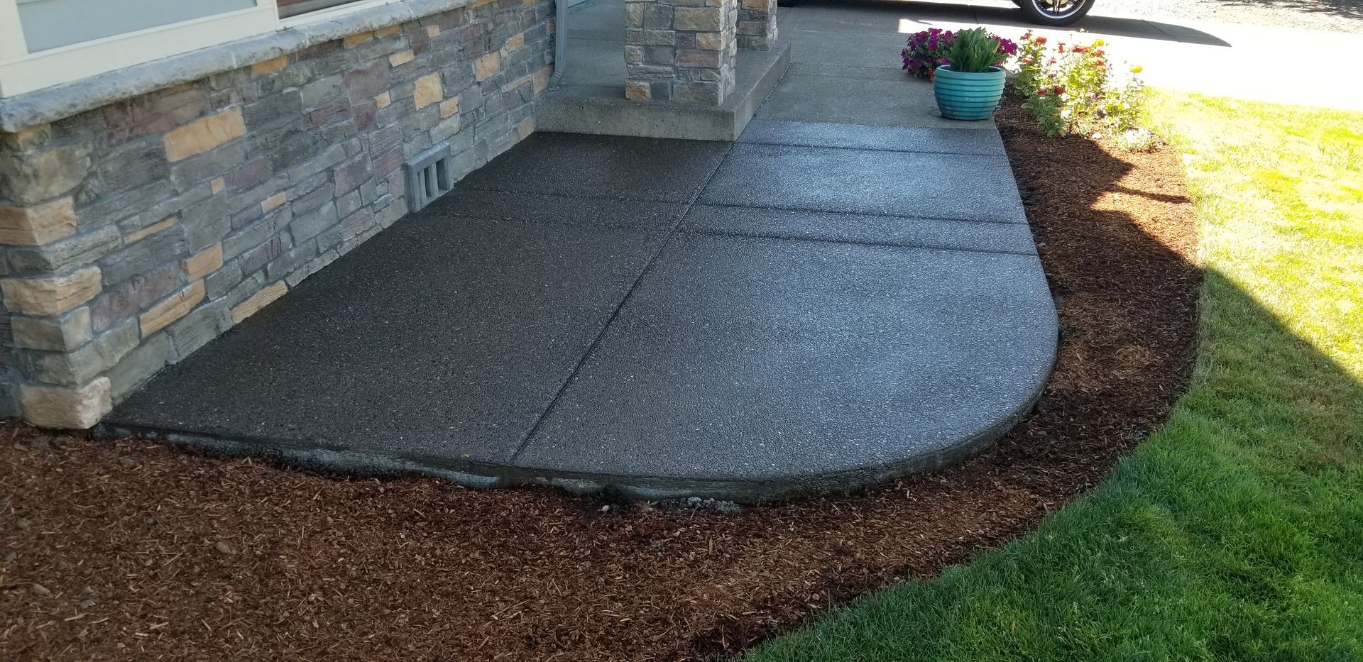 A concrete walkway leading to the front door of a house.