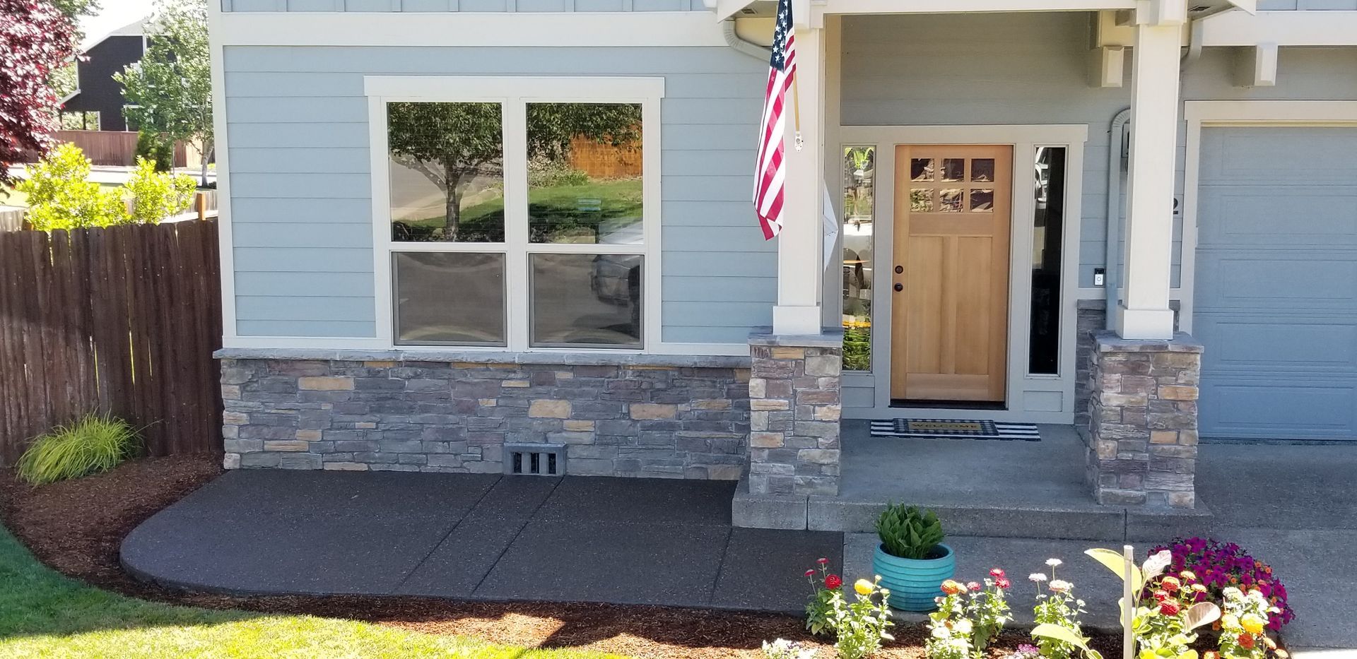 The front of a house with a flag on the porch