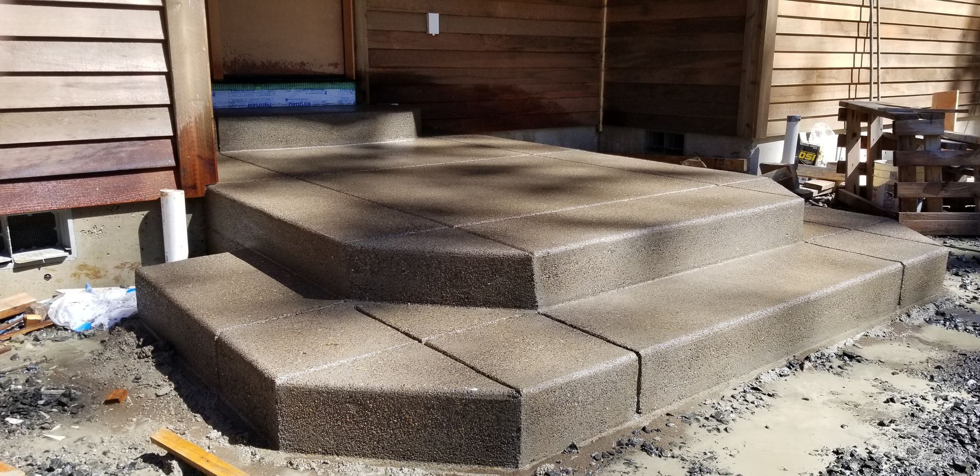 Concrete steps are being built in front of a house