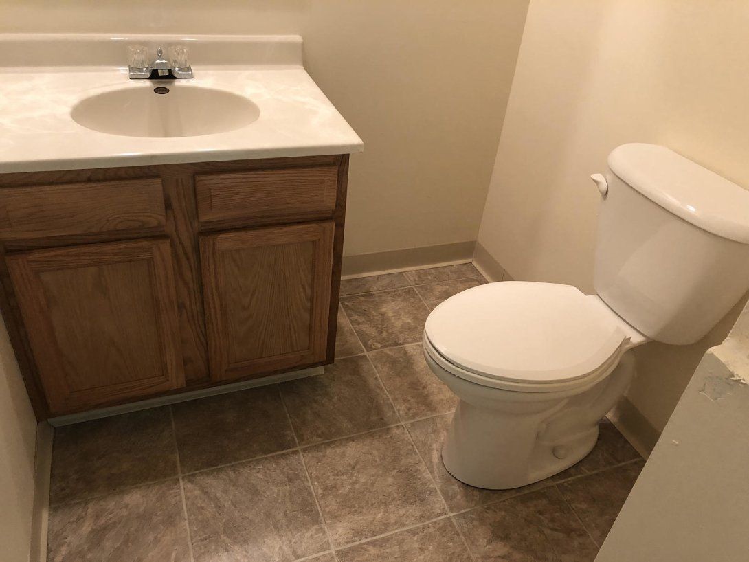 a bathroom with a toilet , sink and cabinets