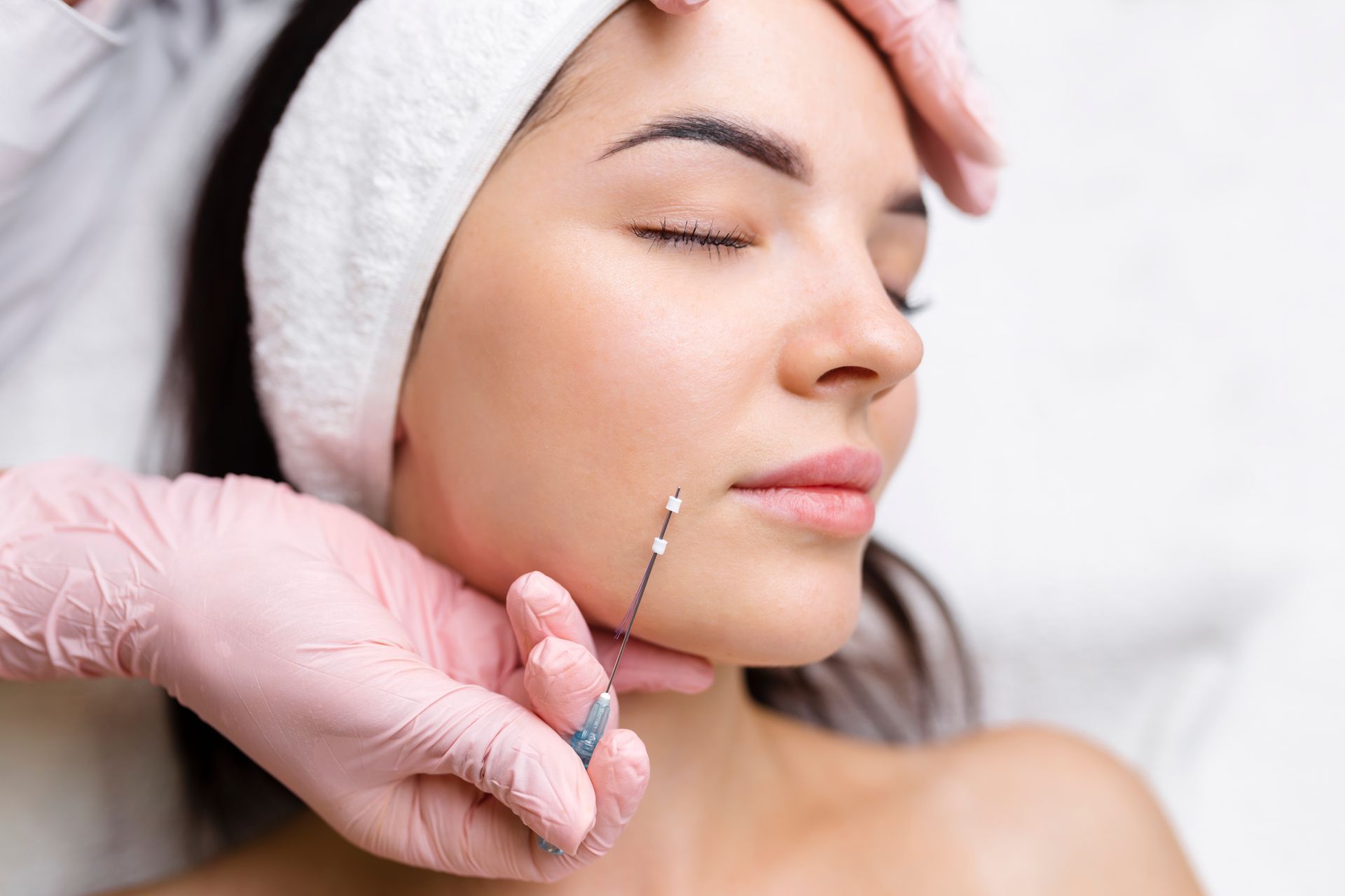 A woman is getting a botox injection in her face.