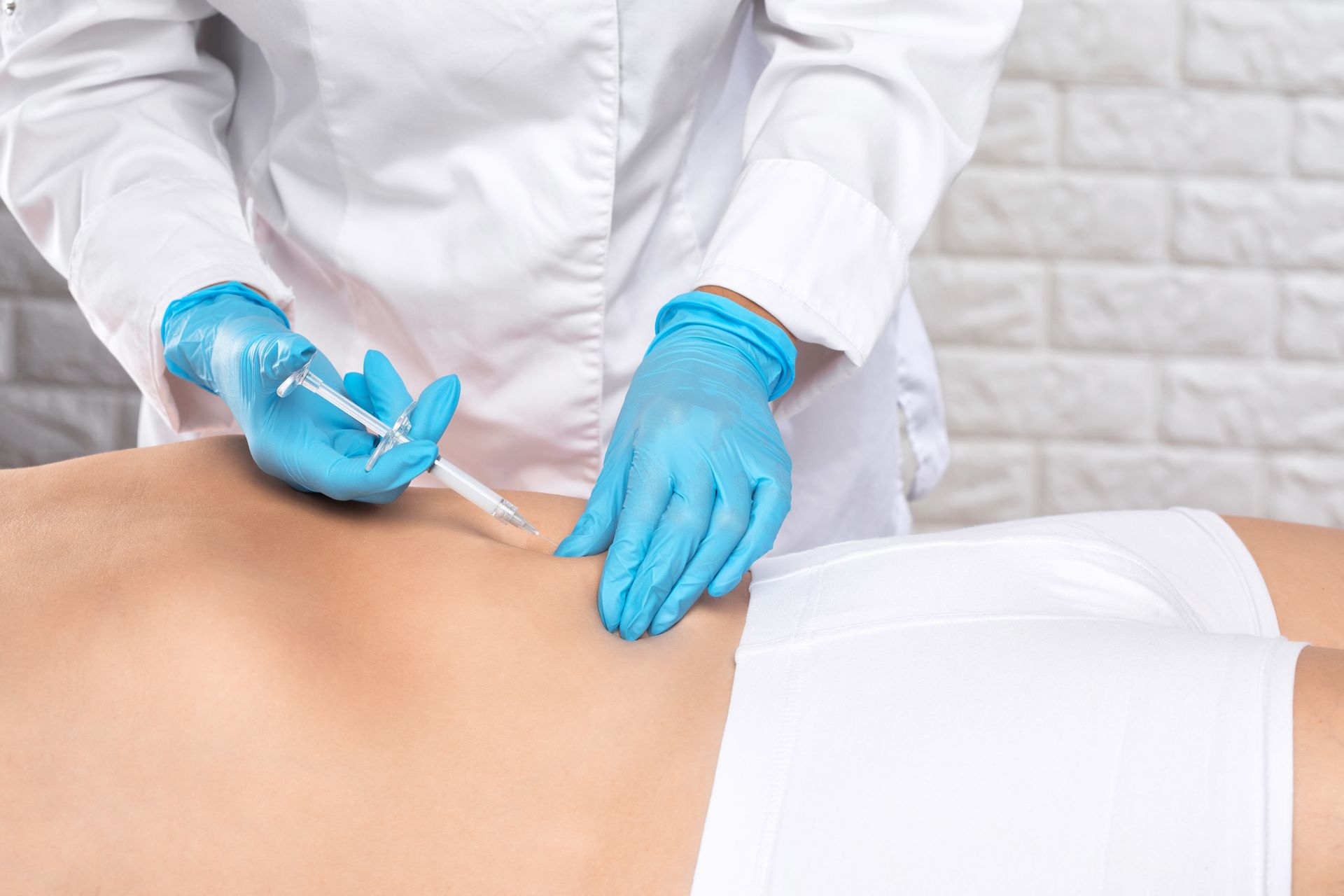 A doctor is giving an injection to a patient 's back.