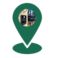 A green pin with a picture of a building inside of it.