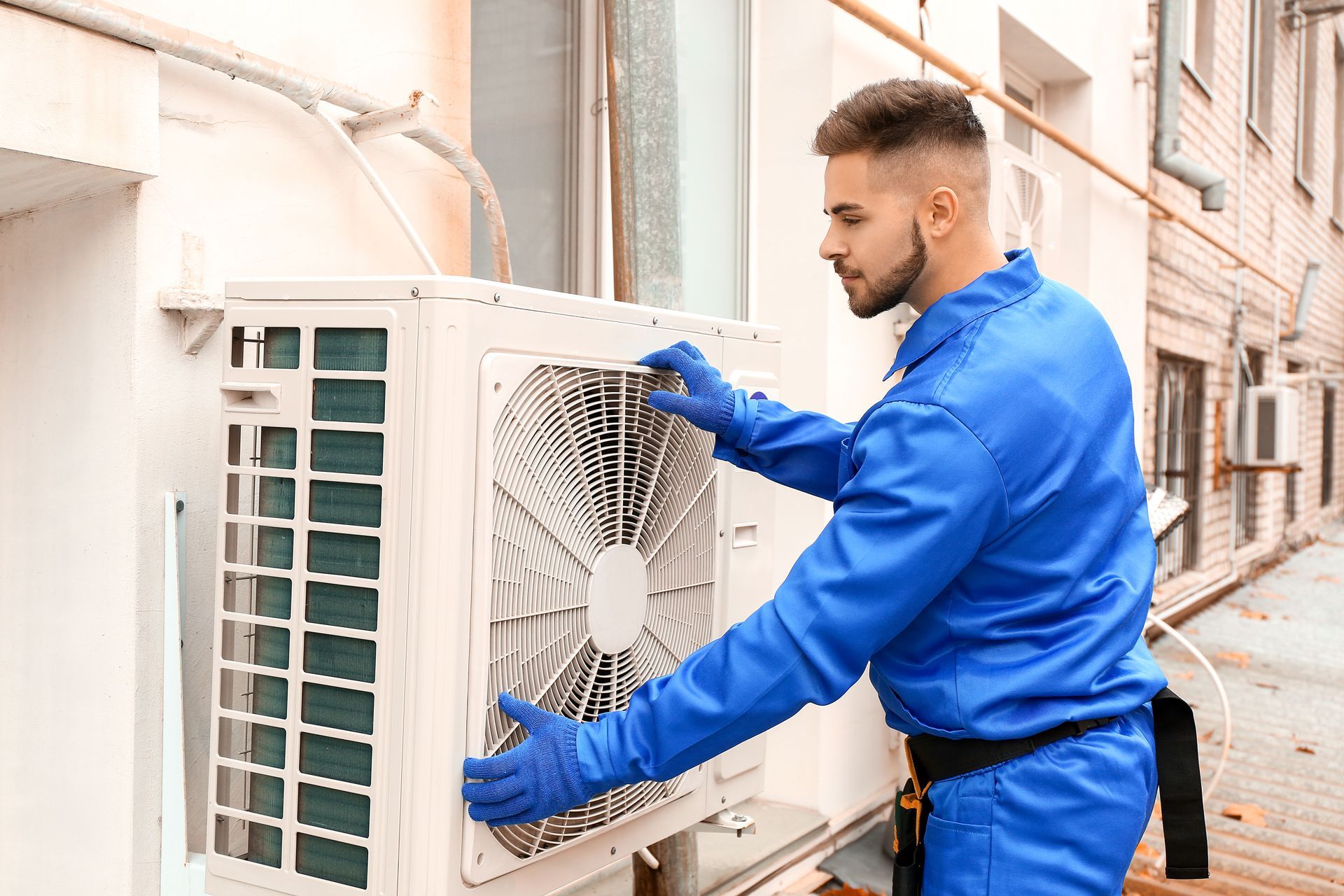A technician installing an outdoor unit of an air conditioner.