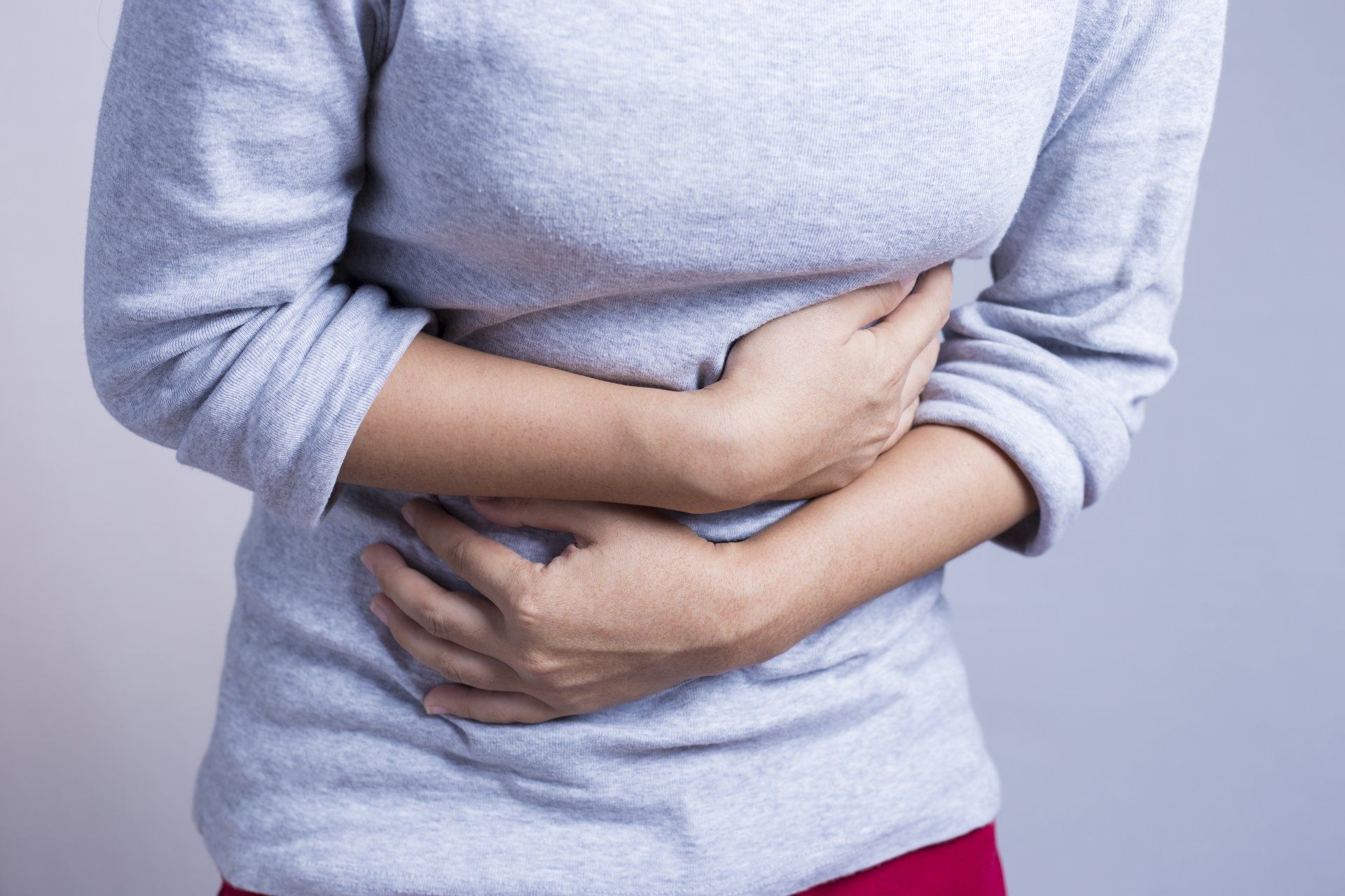 woman pelvic pain clutching stomach