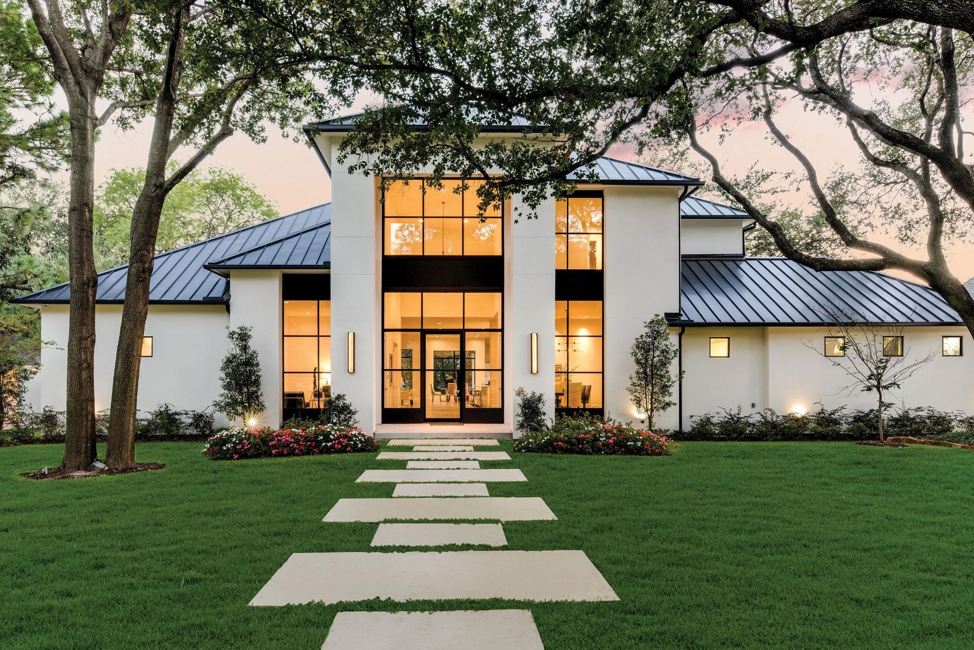 A white house with a blue roof and a walkway leading to it