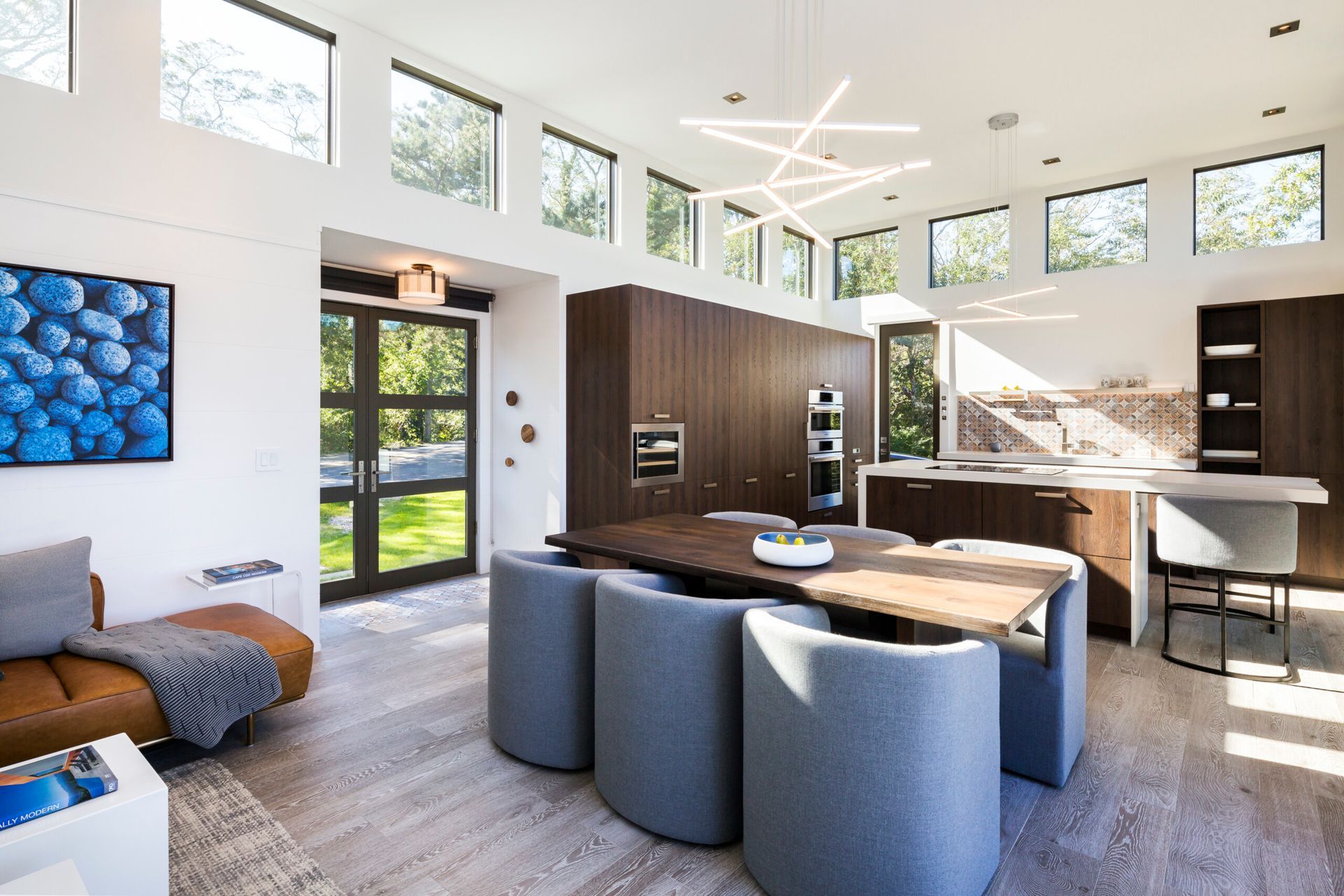 A living room with a dining table and chairs and a kitchen.