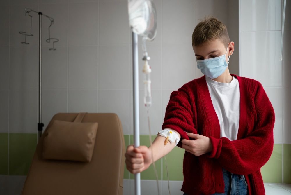 A young man wearing a mask is getting an injection in his arm.