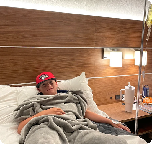A man in a red hat is laying in a hospital bed