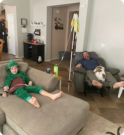 A boy in a dinosaur costume is laying on a couch