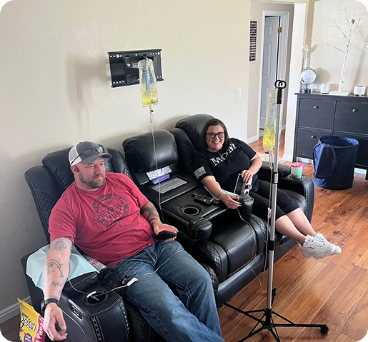 A man and a woman are sitting in chairs in a living room.