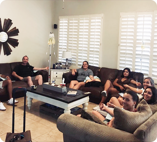A group of people are sitting on couches in a living room.