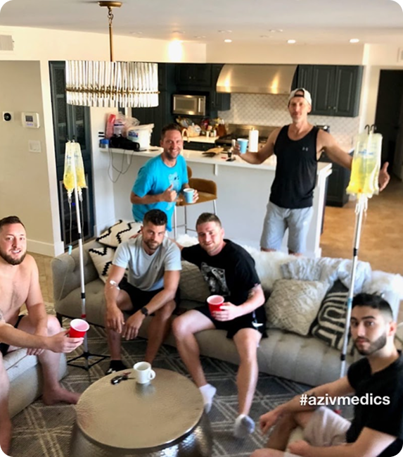 A group of men are sitting on a couch in a living room