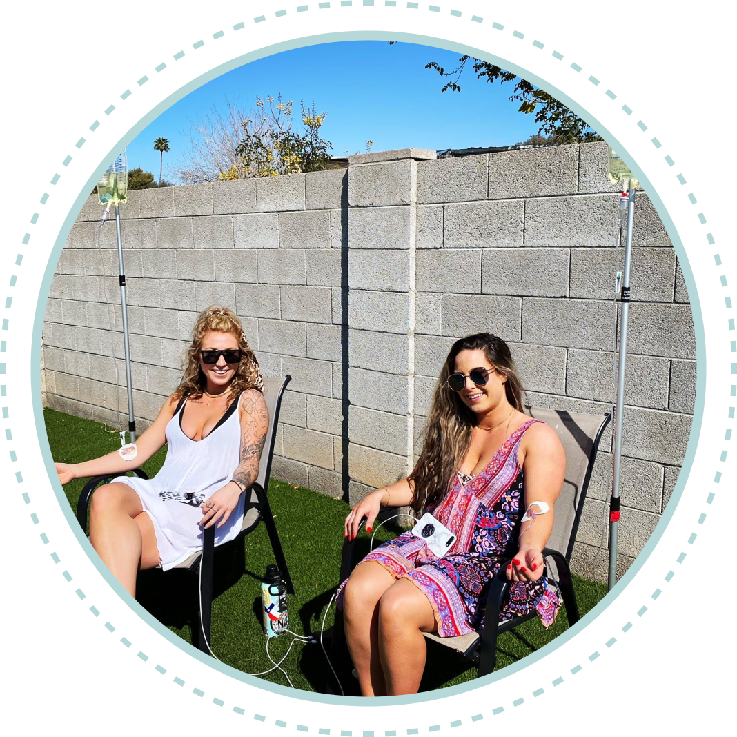 Two women are sitting in chairs in front of a brick wall
