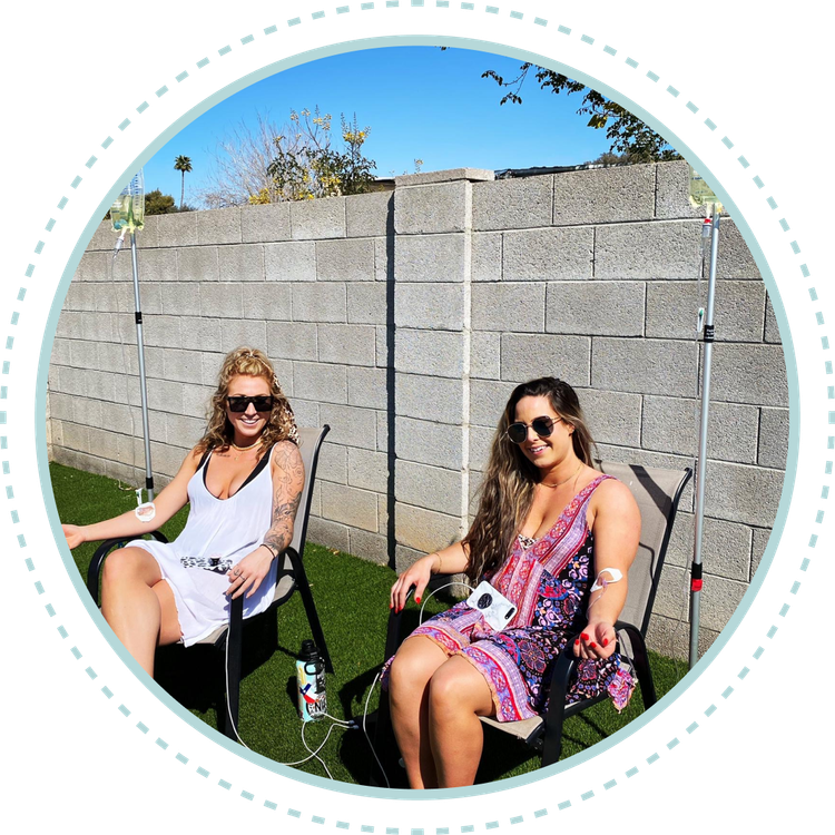 Two women are sitting in chairs in front of a brick wall