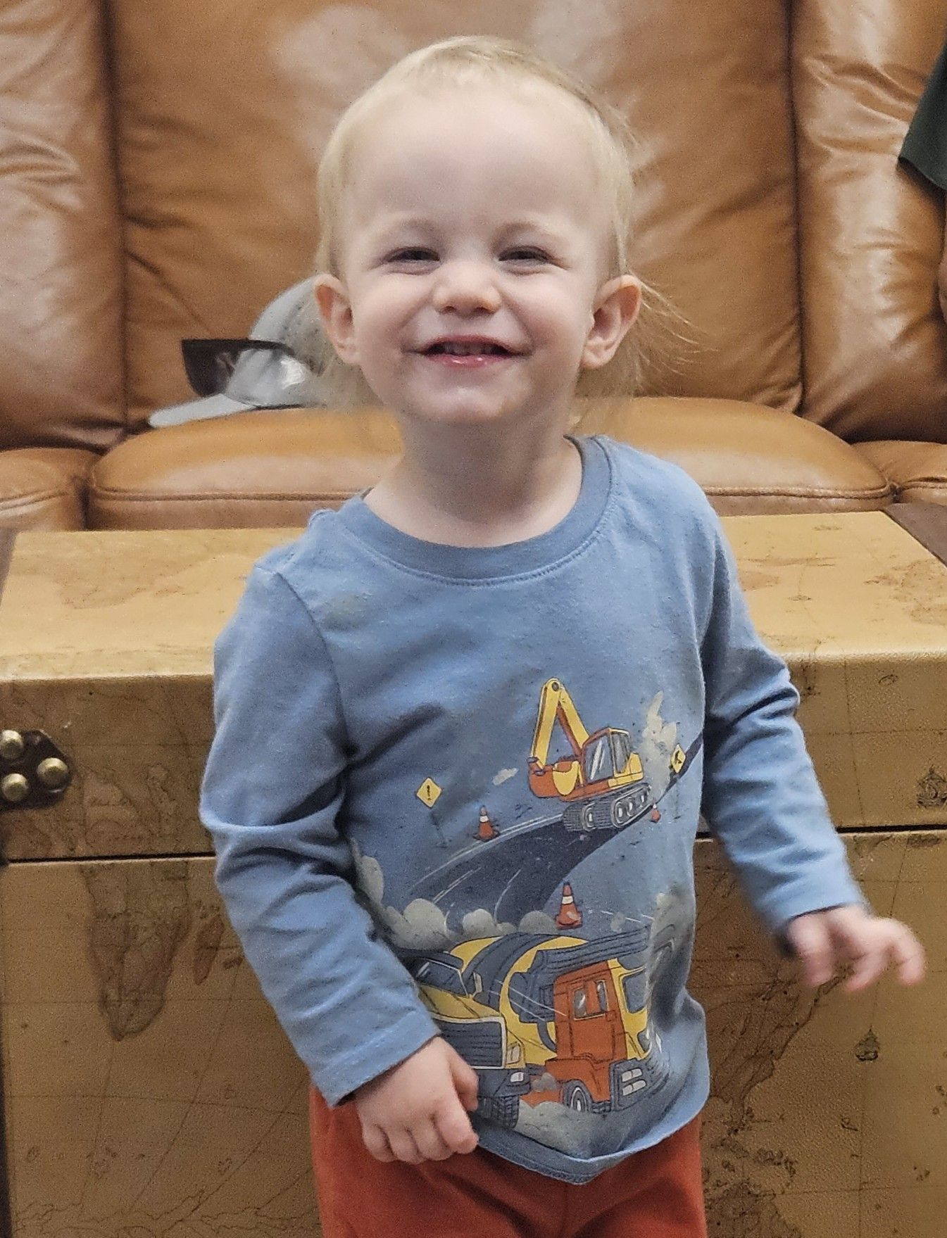 Man smiling in front of a white door wearing a black polo shirt.