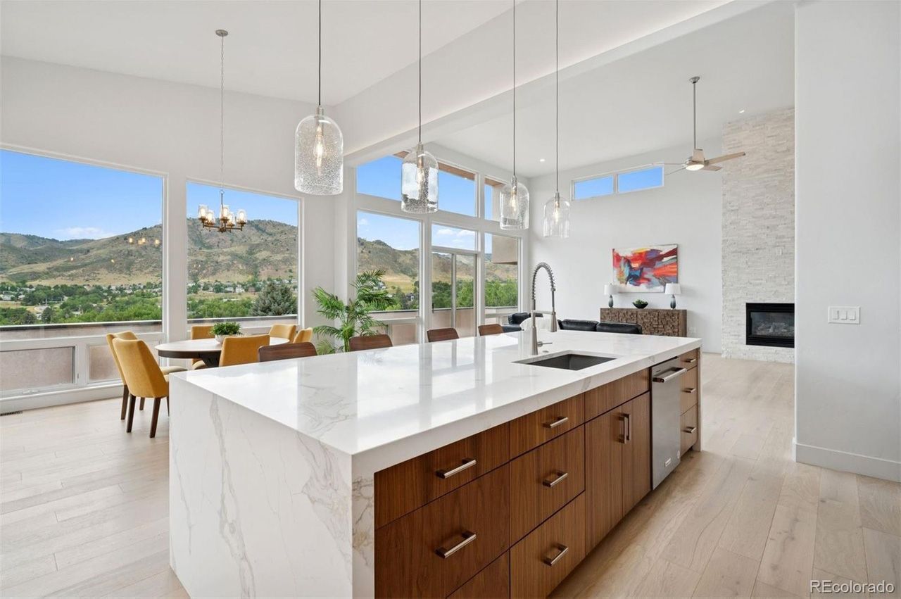 Modern kitchen with large island, floor-to-ceiling windows, and mountain view.