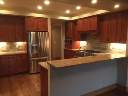 Kitchen with dark wood cabinets, stainless steel appliances, and granite countertops.